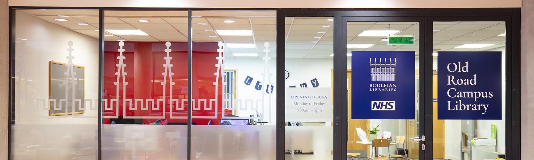 A glass wall and door, with the title Old Road Campus Library and the Bodleian Libraries and NHS logos