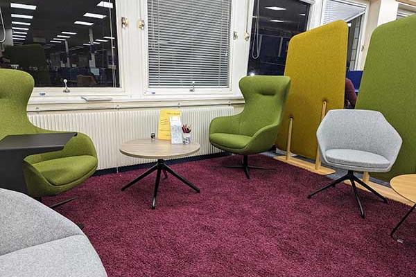 A carpeted area with a variety of comfortable seating